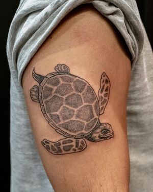 Get a beautifully detailed dotwork turtle tattoo on your upper arm in the vibrant city of London, GB.