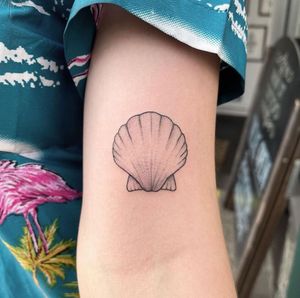 Elegant and detailed clam shellfish tattoo on upper arm by renowned artist Chris Harvey. Perfect for ocean lovers.