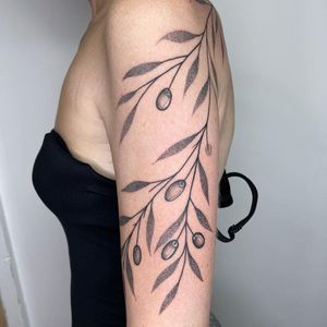 Dotwork upper arm tattoo by Chris Harvey featuring delicate branch and berries design.