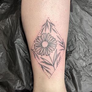 Experience unique dotwork and fine line style detailing in this illustrative lower leg tattoo featuring a beautiful flower and leaf motif by Chris Harvey.