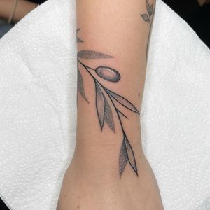 Elegant lower arm tattoo of a delicate leaf design created in fine line and dotwork style by artist Chris Harvey.