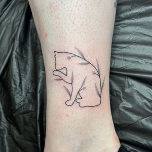 Unique ankle tattoo by Chris Harvey blending dotwork, fine line, and illustrative styles featuring a cat and leaf motif.