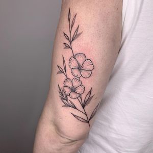 Get intricate floral design by Chris Harvey. Fine line work with detailed leaves for a stunning upper arm tattoo.
