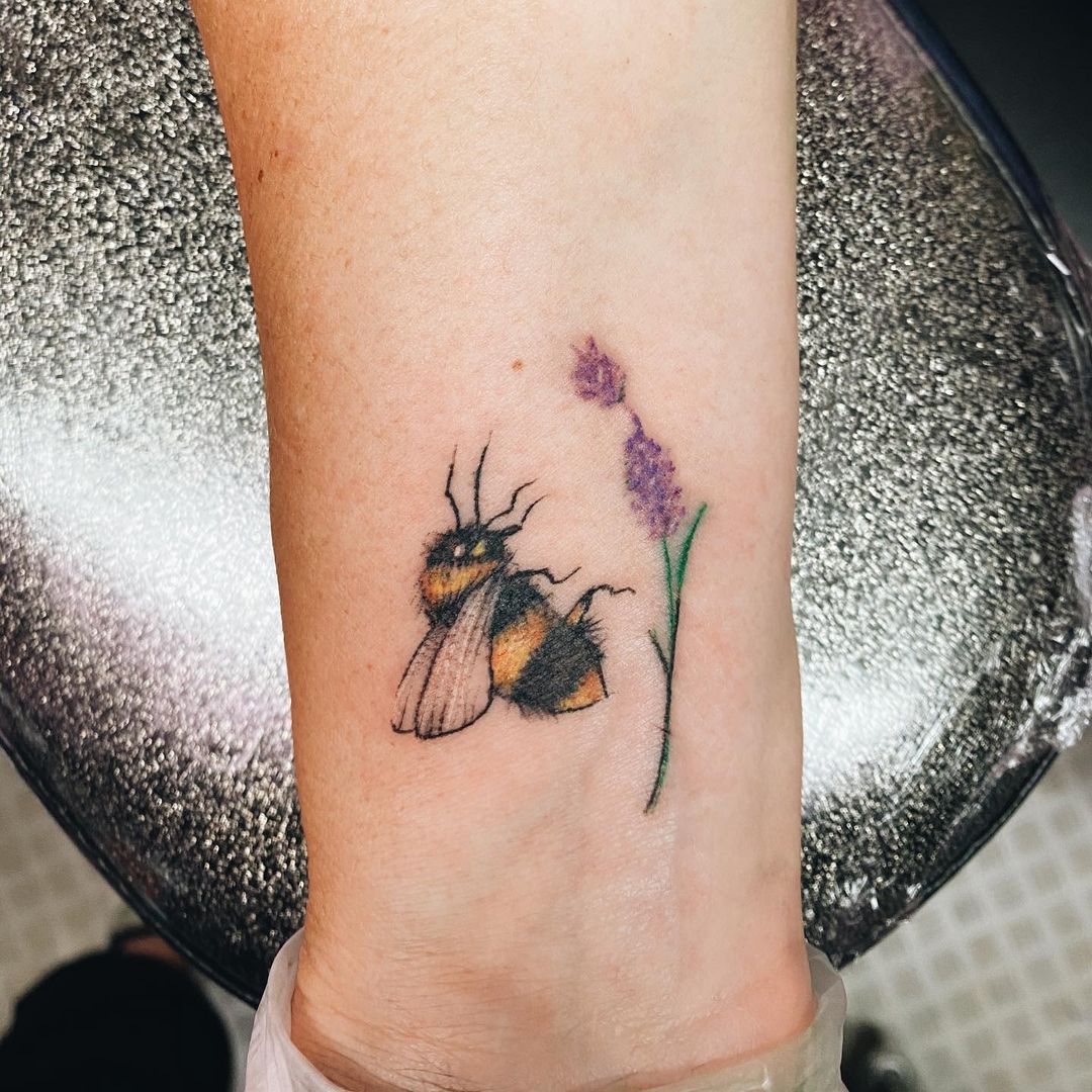 Watercolor flower and bee tattoo on the upper back