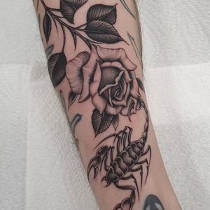 Bold blackwork design by Dani Mawby combining a scorpion and a flower in a traditional style.