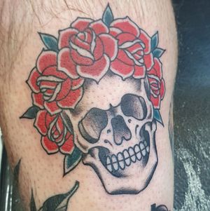 Unique upper leg tattoo by Dani Mawby combining traditional and illustrative styles with a floral and skull motif.