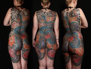 Immerse yourself in ancient Japanese symbolism with this stunning body suit tattoo featuring a powerful dragon and delicate chrysanthemum. Located in London, GB.