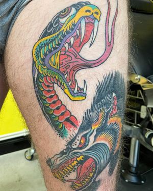 Get a striking illustrative snake tattoo on your upper leg in London. A classic design with a modern twist!