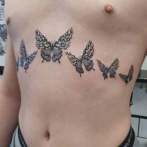 Beautiful blackwork butterfly tattoo on chest by Dani Mawby, perfect for a bold and intricate design.