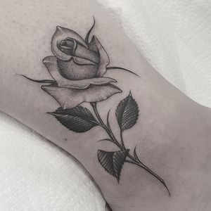 Get a stunning blackwork flower tattoo on your ankle by the talented artist Dani Mawby.