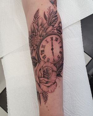 Get a stunning blackwork floral design with a clock motif on your forearm by the talented artist Dani Mawby.