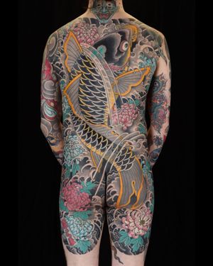 Experience the artistry of traditional Japanese tattoo motifs such as fish, chrysanthemum, and koi fish in this stunning body suit tattoo in London, GB.
