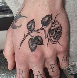 Elegant blackwork flower tattoo on hand done by skilled artist Dani Mawby.
