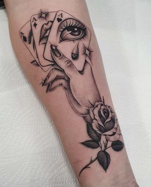 Blackwork forearm tattoo by Dani Mawby featuring a unique combination of flower, hand, and card motifs.