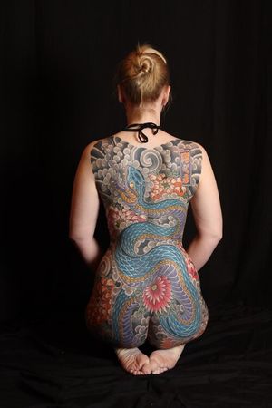 Immerse yourself in the beauty of traditional Japanese tattoos with this stunning body suit by Stewart Robson, featuring a mesmerizing snake and flower motif.