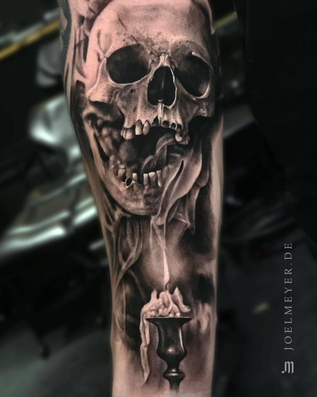 Black and grey skull tattoo on the inner forearm
