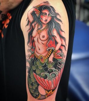 Get a stunning mermaid and woman design with intricate necklace details on your upper arm in London, GB.