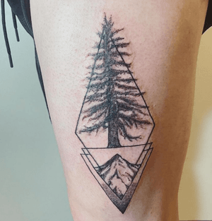 Traveler tattoo featuring a mountain and great pine. 