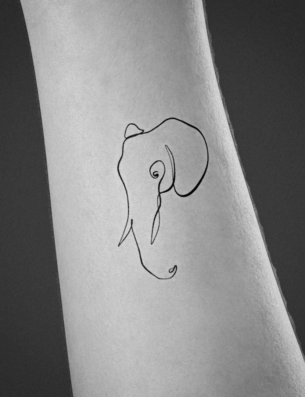 Minimalist elephant tattoo on the wrist.