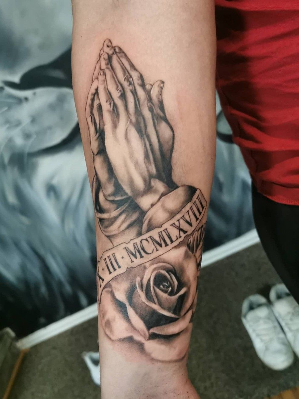 Forearm prayer hands tattoo with roses on Stylevore