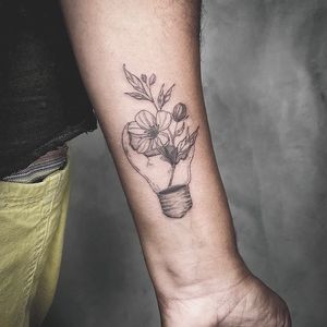 Bold blackwork forearm tattoo featuring a flower and lamp design, perfect for those seeking illustrative ink in LA.