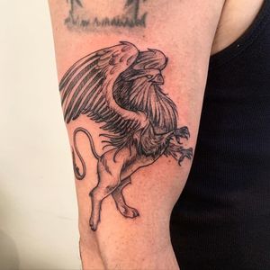 Unique blackwork design featuring an eagle and lion with intricate wings, perfect for your upper arm in New York
