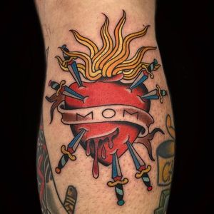 Get a bold and vibrant neo-traditional heart and dagger tattoo on your lower leg in Miami, US. A stunning illustrative design that will make a statement.