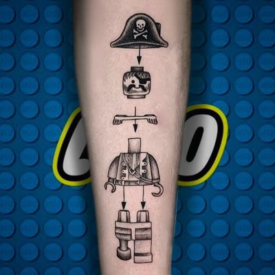 Get a bold blackwork illustrative tattoo of a pirate skull wearing a Playmobil hat on your forearm in Miami, US.