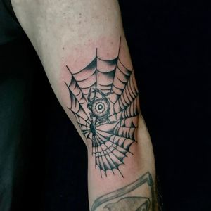 Illustrative blackwork spider and web tattoo on arm in Miami, US. Intricate design for a bold statement.