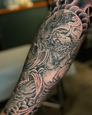 Get an incredible Japanese style forearm tattoo featuring a fierce dragon and the god of thunder, Raijin, by renowned artist Ami James.