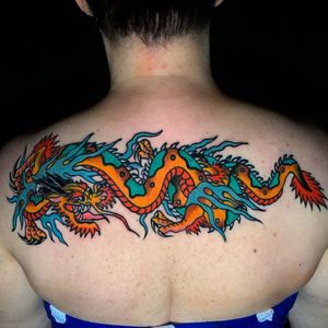 Immerse yourself in the mystique of Japanese art with a powerful dragon motif adorning your upper back in vibrant Miami.
