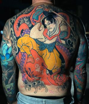 Immerse yourself in the world of Japanese art with this intricate tattoo featuring an octopus, peony, sword, samurai, waves, and fingerwaves on your back. Get it done in Miami, US!