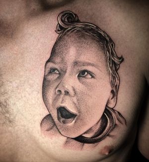 Capture the innocence and beauty of childhood with a stunning realism tattoo on your chest by Rico Dionichi.