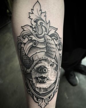 Blackwork forearm tattoo featuring a detailed dog design with delicate filigree accents. By tattoo artist Rico Dionichi.
