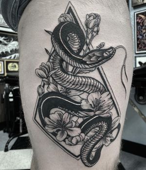 Get inked with a stunning blackwork illustrative tattoo of a snake and flower, expertly done by Rico Dionichi on your upper leg.