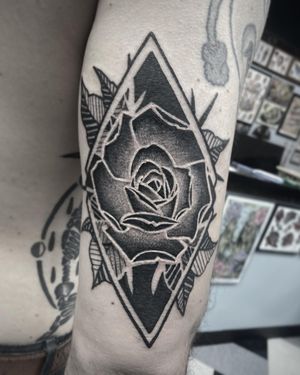 Illustrative peony flower tattoo on forearm, designed by Rico Dionichi. Bold and striking blackwork style.