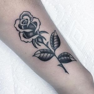 Unique blackwork flower tattoo on forearm by Chris Tambo, featuring intricate illustrative design.