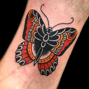 Experience the beauty of a classic illustrative butterfly tattoo on your arm by artist Chris Tambo.