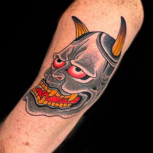Experience the beauty and mystery of the hannya mask with this stunning Japanese tattoo on your upper arm. Let Chris Tambo's expertise bring this traditional design to life.