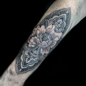Beautiful blackwork and illustrative design by Chris Tambo showcasing a stunning peony flower motif on the forearm.