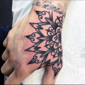 Get a stunning geometric mandala tattoo on your hand in London, GB. Intricate and illustrative design.