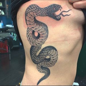 Get a captivating black and grey Japanese snake tattoo on your ribs in London, GB. Embrace the mystique and elegance of this ancient motif.