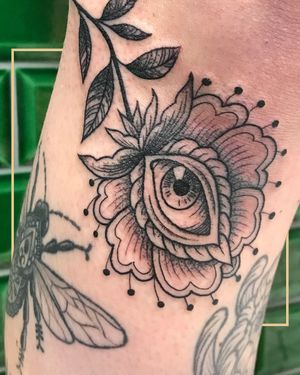 Unique black & gray neo-traditional design of a flower intertwined with an eye, perfect for your arm in London.