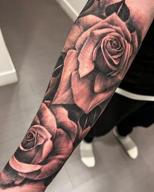 Beautiful flower design on forearm in detailed black and gray realism style by artist Corei.