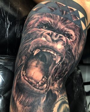 Impressive black and gray gorilla tattoo by Corei, showcasing exceptional realism on the upper arm.