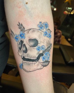 Get a stunning illustrative tattoo on your forearm featuring a delicate flower and skull design done in fine-line style in London, GB.