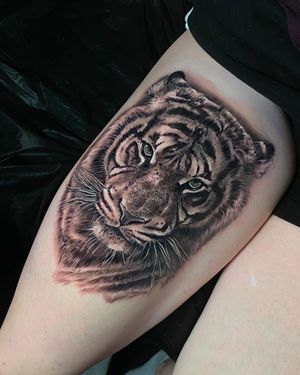 Get a stunning black and gray tiger tattoo done in London. Let this fierce and majestic creature adorn your upper leg with realism.