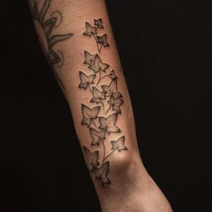 Get a stunning black and gray leaf tattoo on your upper arm in London, UK. This timeless design is perfect for nature lovers.