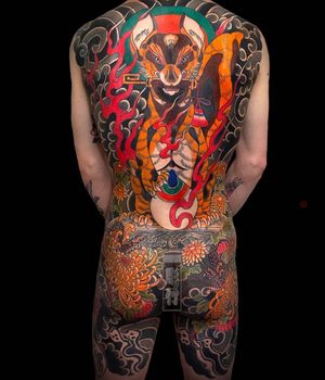 This stunning illustrative tattoo features a fierce tiger, elegant chrysanthemum flower, fiery flames, symbolic key, and swirling clouds, all expertly done in traditional Japanese style. Perfect for those looking to make a bold statement. Located in London, GB.