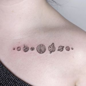 Get a stunning fine line illustration of a planet on your shoulder in London. Perfect for space lovers!
